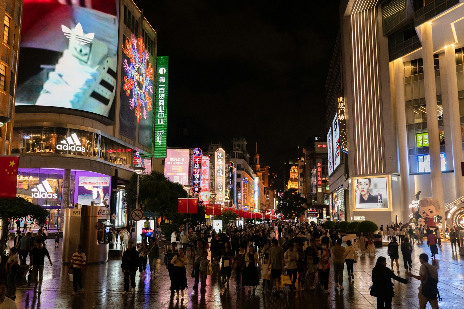 Multitud paseando por Nanjing Road entre edificios altos en Shanghái