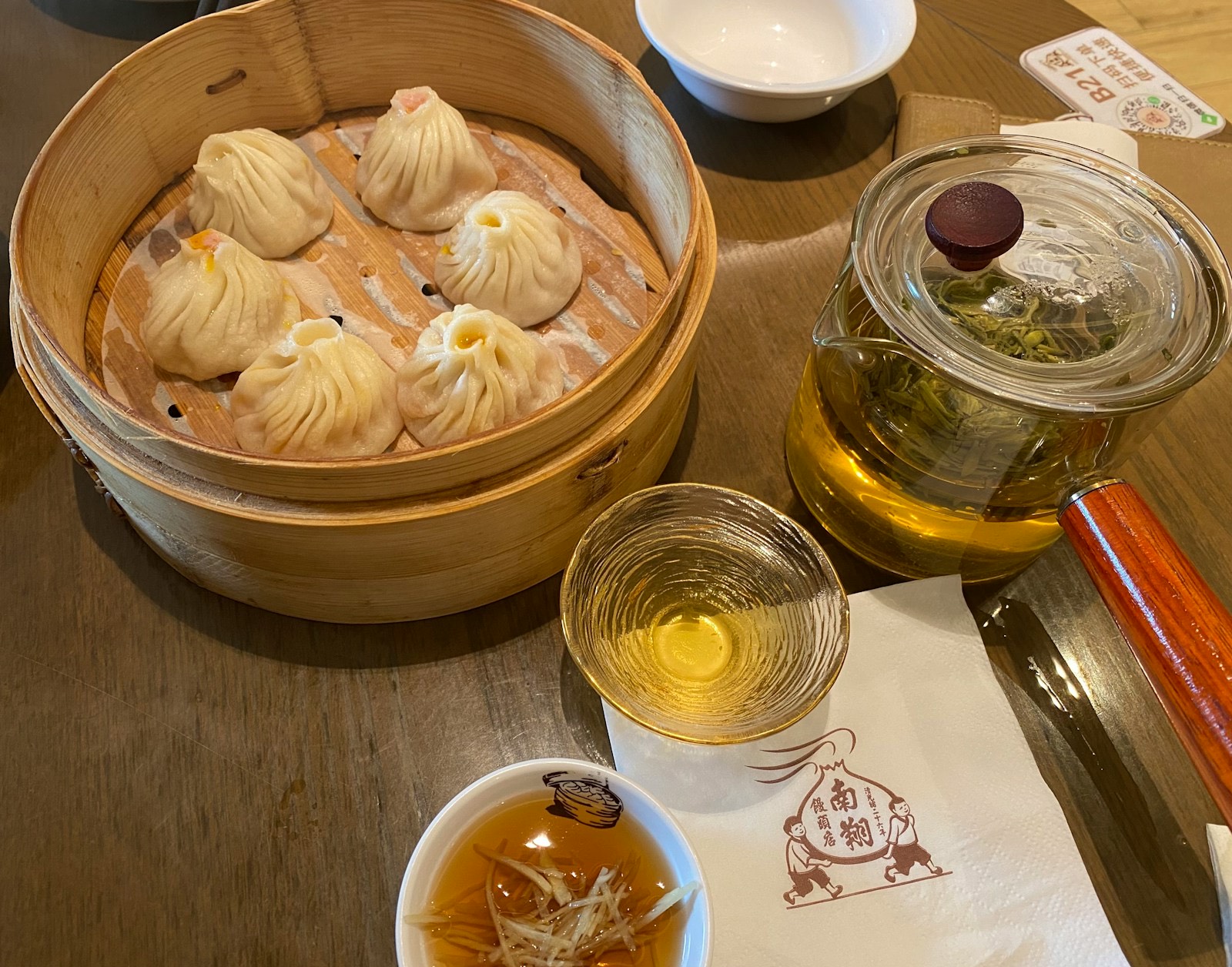 Xiaolongbao, dumplings rellenos de caldo, en una vaporera de bambú con té